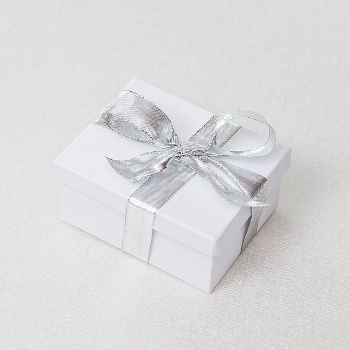 A gift box tied with a Crystal ribbon on a light background at Falkensteiner Hotels & Residences