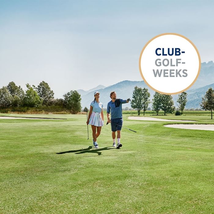 Two golfers walking on a golf course with 