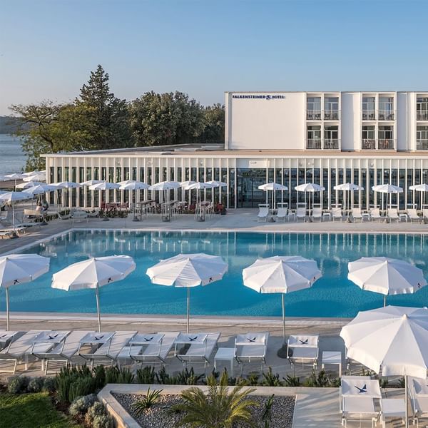Exterior view of hotel facade and outdoor pool with loungers at Falkensteiner Hotel Park Punat