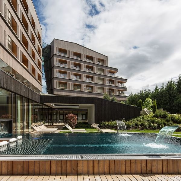 Exterior view of Falkensteiner Hotel Schladming with an outdoor pool and trees