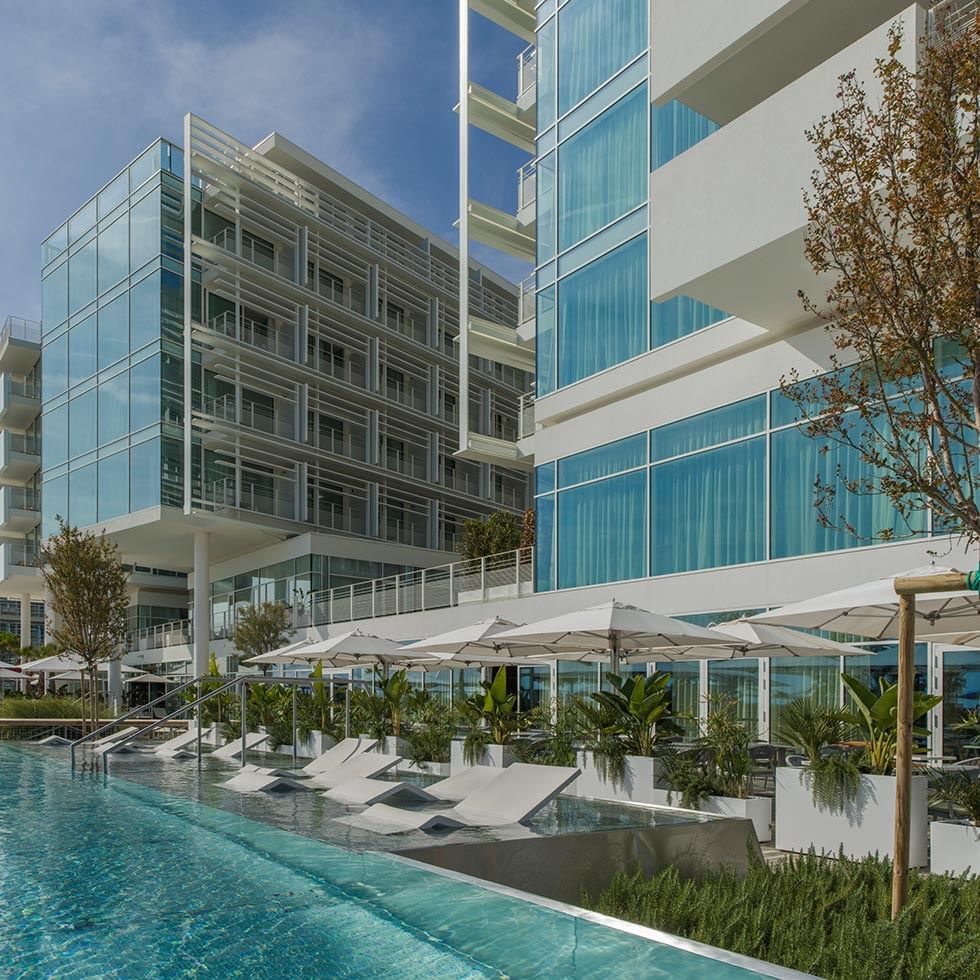 Angle view of the hotel exterior with pool and sunbeds at Falkensteiner Hotel & Spa Jesolo