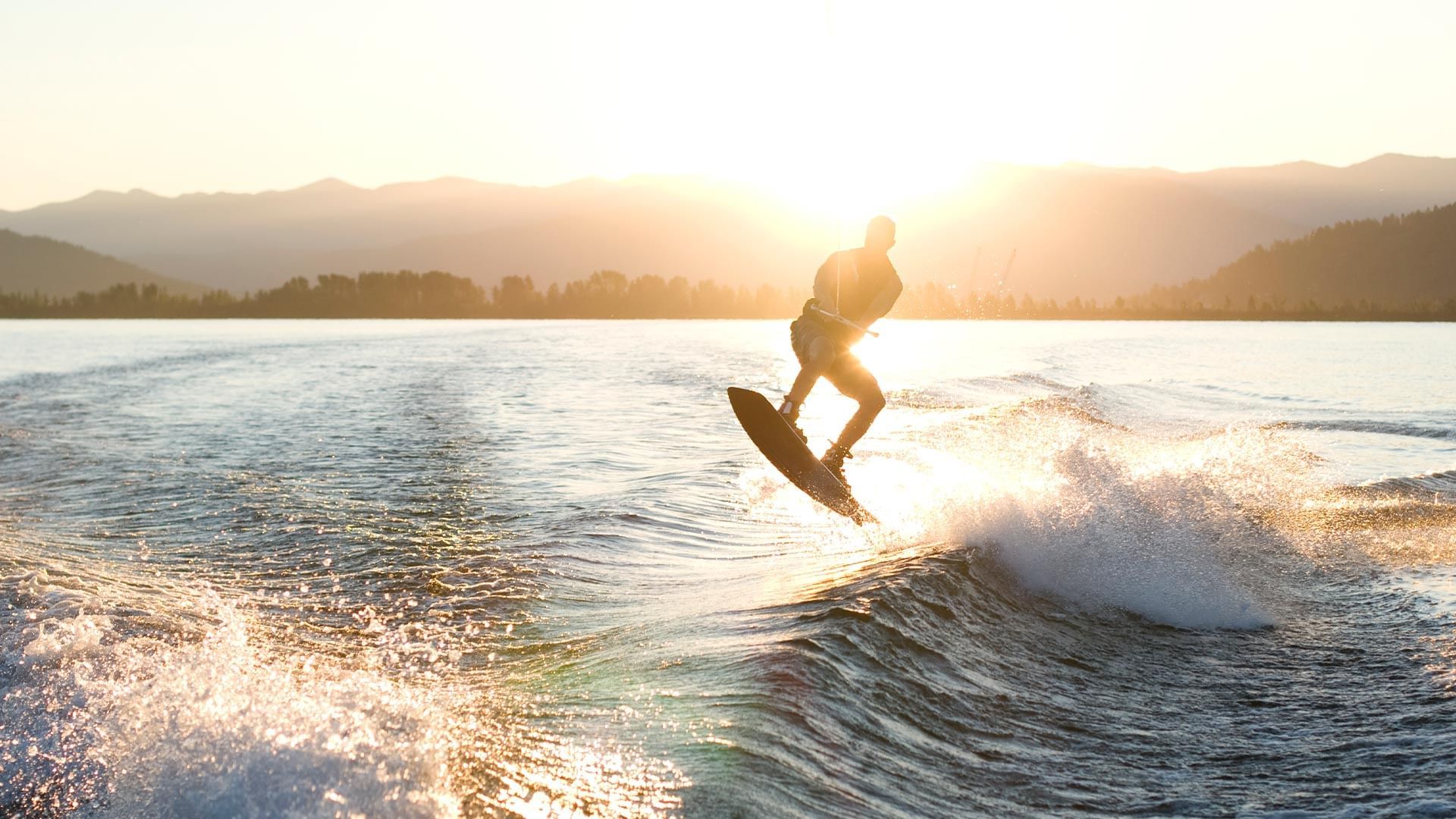 Man surfing on the beach at sunset near Falkensteiner Hotels & Residences