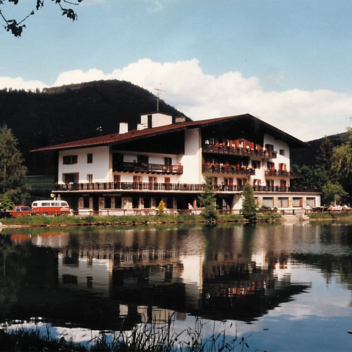 Distant exterior view of the hotel by lake & mountains at Falkensteiner Hotels & Residences