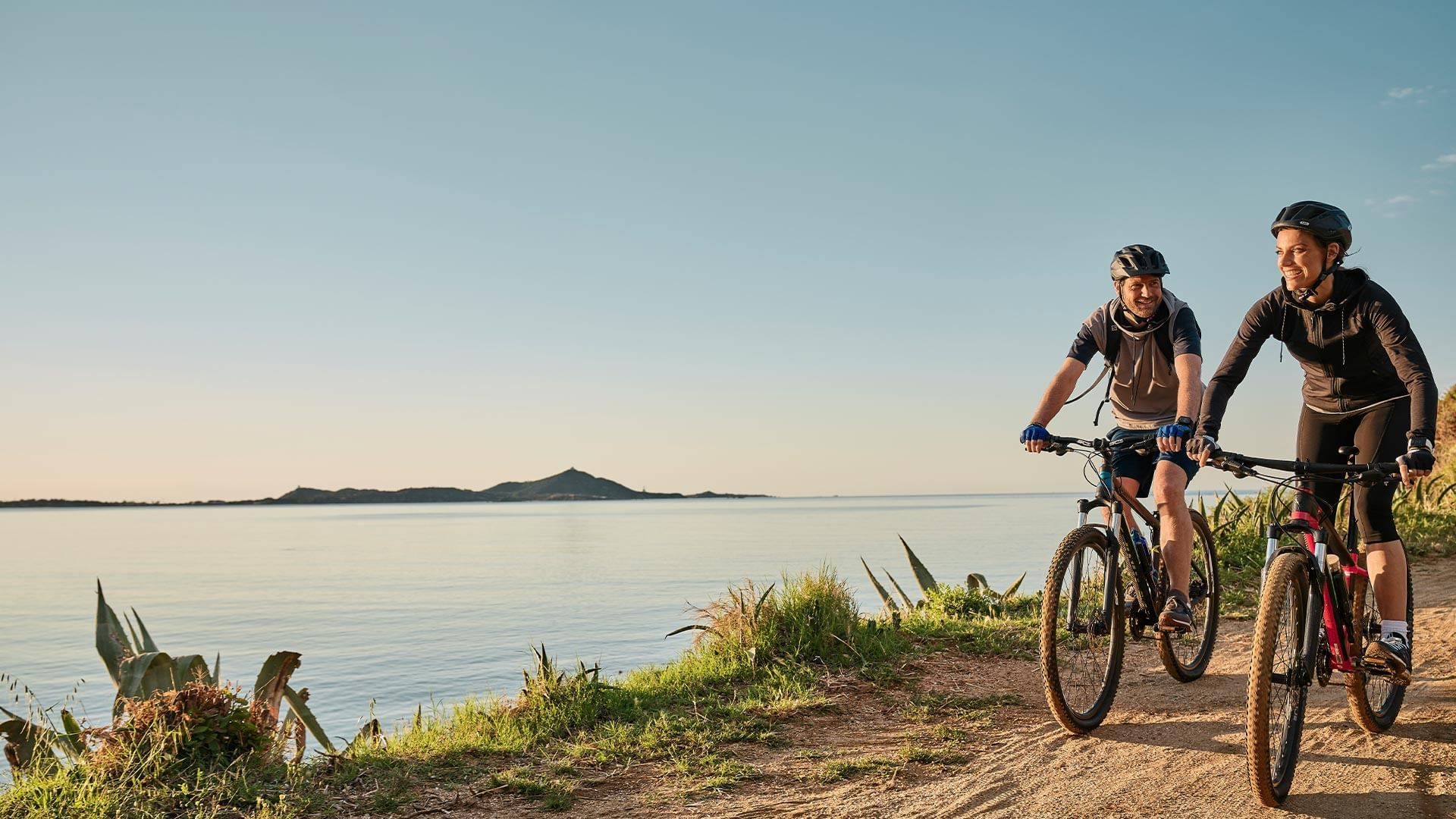 Two cyclists riding along a coastal path near the Falkensteiner Hotels & Residences