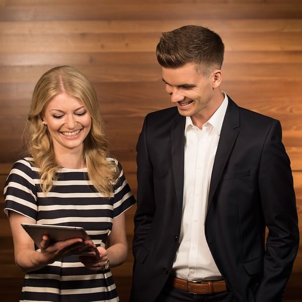 A couple looking at a tablet device at Falkensteiner Hotels & Residences