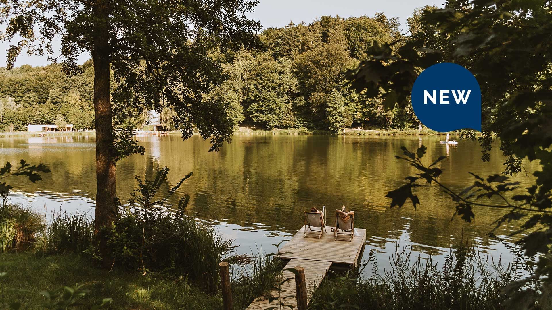 Poster with NEW sign and wooden dock on Lake Blaguš with two chairs near Falkensteiner Hotels & Residences