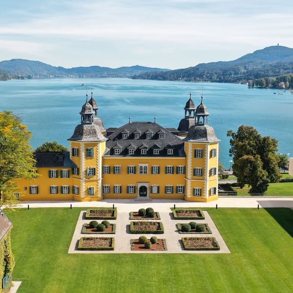 Distance exterior of the hotel building overlooking the sea at Falkensteiner Schlosshotel Velden
