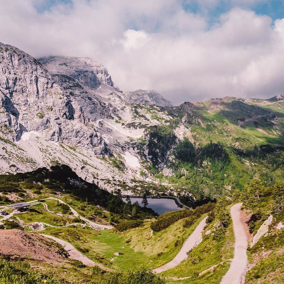 Mountain path through lush greenery with rocky peaks near Falkensteiner Hotels & Residences